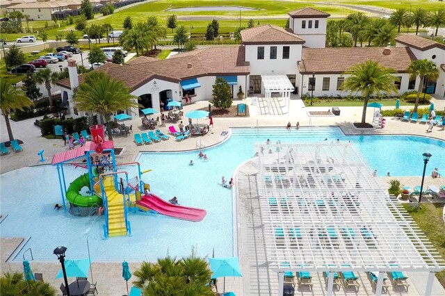 2439 Dubai St, Kissimmee, FL 34747 - community pool featuring a water play area, a water slide, and a pergola