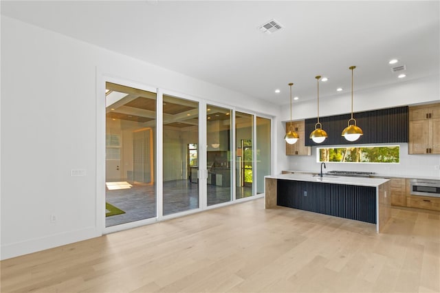 7706 Ficquette Rd, Windermere, FL 34786 - kitchen with light countertops, light wood-type flooring, an island with sink, pendant lighting, and recessed lighting