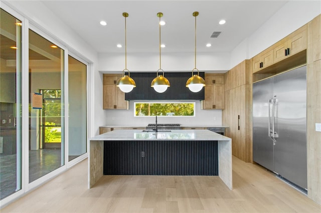 7706 Ficquette Rd, Windermere, FL 34786 - kitchen with built in fridge, light brown cabinets, light countertops, a kitchen island with sink, and decorative backsplash