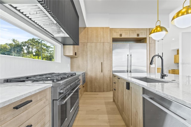 7706 Ficquette Rd, Windermere, FL 34786 - kitchen featuring premium appliances, light brown cabinets, light wood-style flooring, and light stone countertops