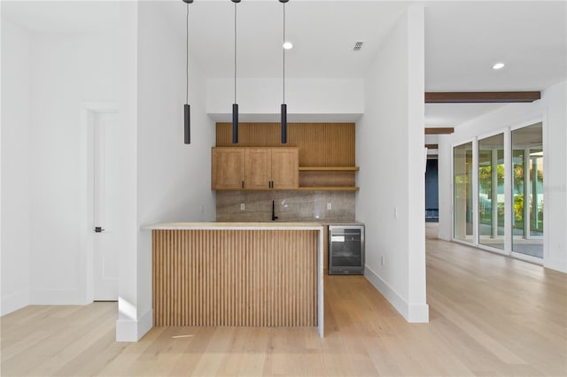 7706 Ficquette Rd, Windermere, FL 34786 - kitchen featuring wine cooler, tasteful backsplash, light wood-style floors, brown cabinets, and light countertops