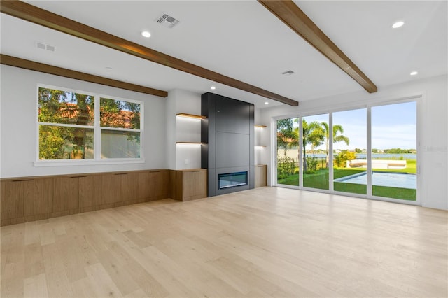 7706 Ficquette Rd, Windermere, FL 34786 - unfurnished living room featuring beamed ceiling, a fireplace, light wood-style floors, and recessed lighting