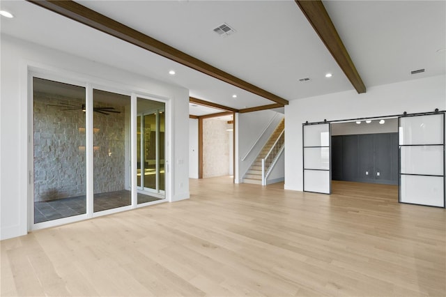 7706 Ficquette Rd, Windermere, FL 34786 - unfurnished living room with beamed ceiling, light wood finished floors, a barn door, stairway, and a ceiling fan