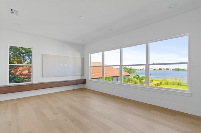 7706 Ficquette Rd, Windermere, FL 34786 - spare room featuring a water view, light wood finished floors, and plenty of natural light