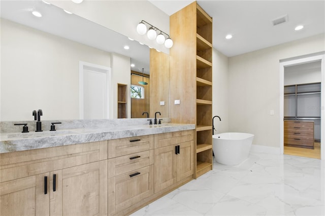 7706 Ficquette Rd, Windermere, FL 34786 - bathroom with double vanity, a freestanding tub, marble finish flooring, recessed lighting, and a walk in closet
