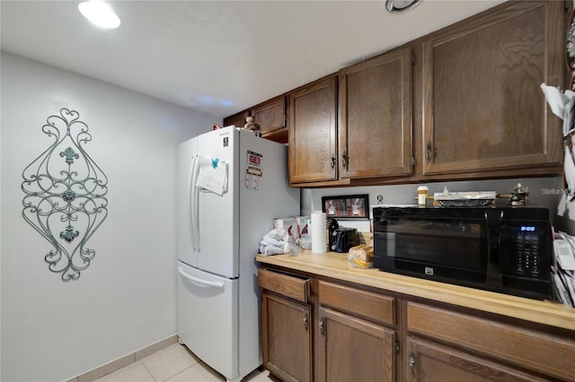 2826 NE 7th St, Ocala, FL 34470 - kitchen featuring freestanding refrigerator, black microwave, and light tile patterned floors