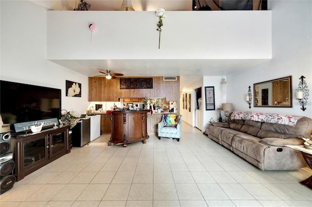 2826 NE 7th St, Ocala, FL 34470 - living room featuring a ceiling fan, light tile patterned flooring, a high ceiling, and wooden walls