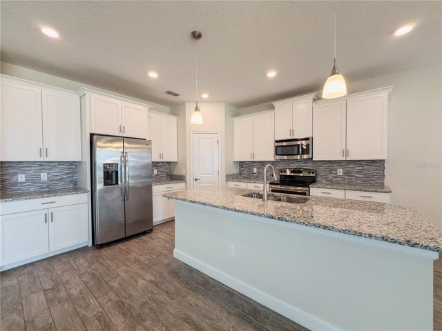 4632 Egg Harbor Dr, Kissimmee, FL 34746 - kitchen with stainless steel appliances, a sink, tasteful backsplash, dark wood-style flooring, and a textured ceiling