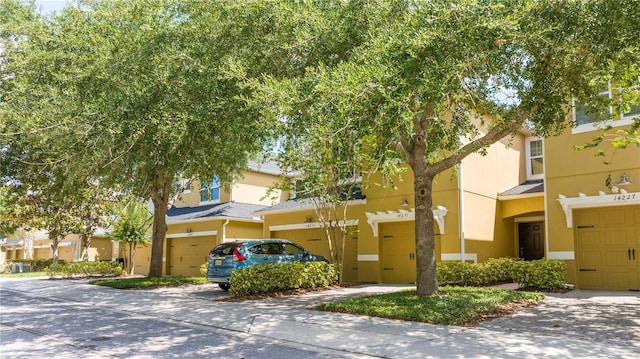 14231 Desert Haven St Unit Ge, Windermere, FL 34786 - view of front of house featuring a garage, stucco siding, and driveway