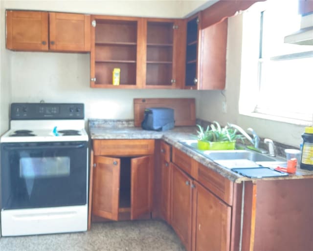 58 W 27th St Unit N, West Palm Beach, FL 33404 - kitchen with range with electric cooktop, a sink, light countertops, brown cabinets, and dark aggregate flooring