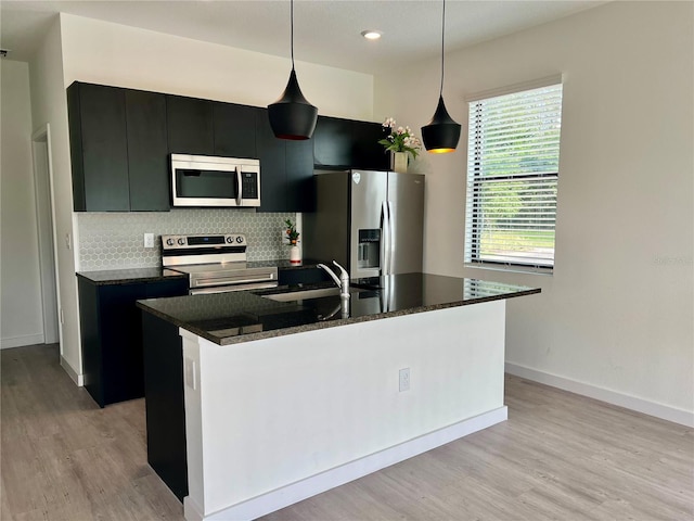 3301 Tranquil Trl, Kissimmee, FL 34747 - kitchen featuring stainless steel appliances, a sink, dark cabinets, an island with sink, and recessed lighting