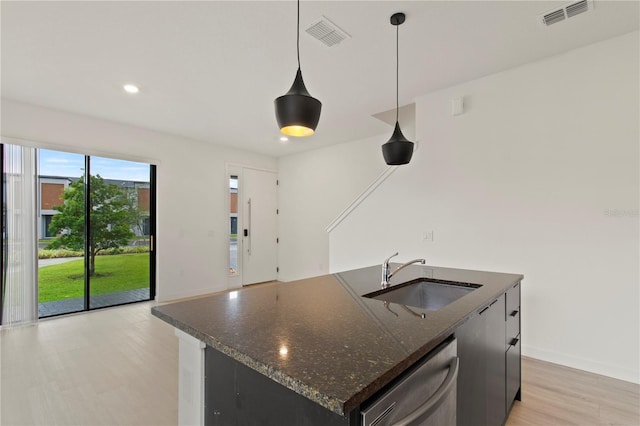3301 Tranquil Trl, Kissimmee, FL 34747 - kitchen with stainless steel dishwasher, light wood-style flooring, recessed lighting, pendant lighting, and a center island with sink