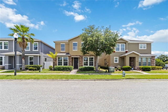 5217 Creekside Park Ave, Orlando, FL 32811 - view of front of home featuring stone siding, stucco siding, central air condition unit, and a front lawn