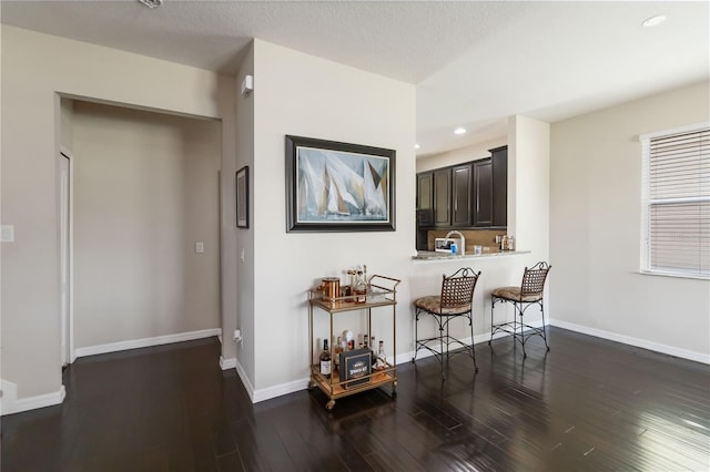 5217 Creekside Park Ave, Orlando, FL 32811 - kitchen with a kitchen bar, recessed lighting, wood finished floors, baseboards, and a peninsula