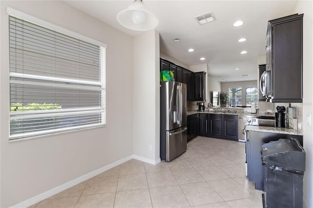 5217 Creekside Park Ave, Orlando, FL 32811 - kitchen with stainless steel appliances, light stone counters, light tile patterned flooring, recessed lighting, and baseboards