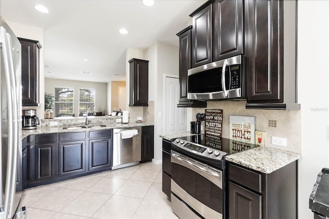 5217 Creekside Park Ave, Orlando, FL 32811 - kitchen featuring stainless steel appliances, a sink, decorative backsplash, light stone countertops, and light tile patterned floors