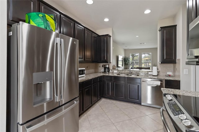 5217 Creekside Park Ave, Orlando, FL 32811 - kitchen with appliances with stainless steel finishes, a sink, light stone counters, light tile patterned flooring, and recessed lighting