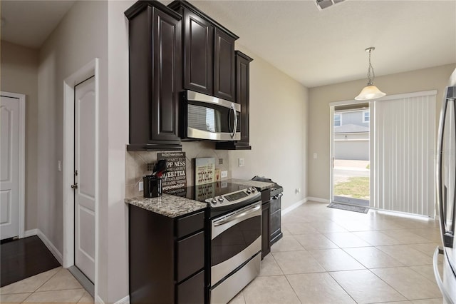 5217 Creekside Park Ave, Orlando, FL 32811 - kitchen with stainless steel appliances, backsplash, light stone countertops, baseboards, and light tile patterned floors