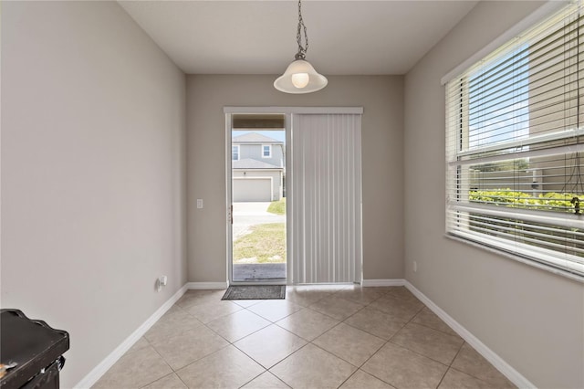 5217 Creekside Park Ave, Orlando, FL 32811 - doorway to outside with healthy amount of natural light, light tile patterned floors, and baseboards