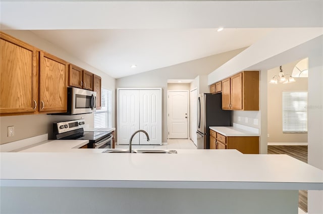 4305 Balmoral Ct, Wesley Chapel, FL 33543 - kitchen with appliances with stainless steel finishes, a sink, vaulted ceiling, light countertops, and brown cabinets