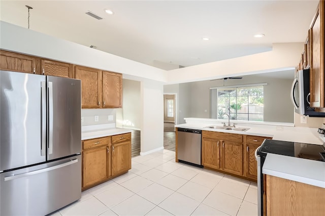 4305 Balmoral Ct, Wesley Chapel, FL 33543 - kitchen with stainless steel appliances, a sink, brown cabinetry, light countertops, and light tile patterned flooring