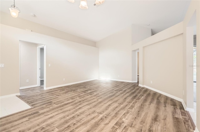 4305 Balmoral Ct, Wesley Chapel, FL 33543 - empty room with wood finished floors, baseboards, and vaulted ceiling