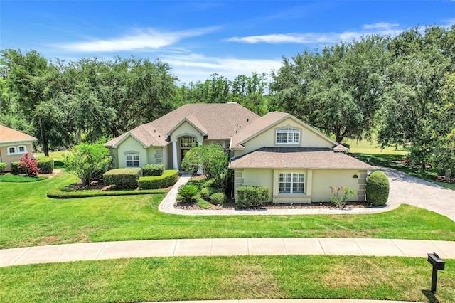 11602 Graces Way, Clermont, FL 34711 - view of front of home with stucco siding, a front lawn, roof with shingles, and view of wooded area