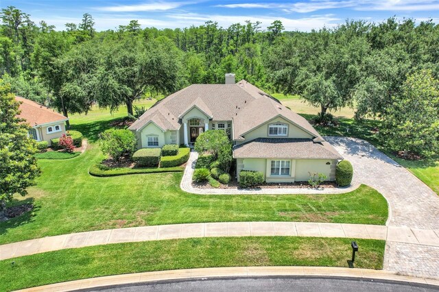 11602 Graces Way, Clermont, FL 34711 - view of front of house featuring decorative driveway, a front yard, a chimney, and stucco siding