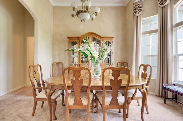 11602 Graces Way, Clermont, FL 34711 - dining space featuring a chandelier, light colored carpet, arched walkways, crown molding, and baseboards