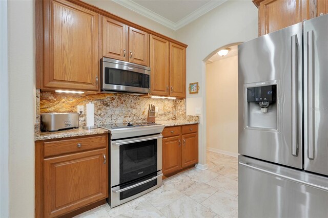 11602 Graces Way, Clermont, FL 34711 - kitchen featuring stainless steel appliances, ornamental molding, tasteful backsplash, arched walkways, and light stone counters