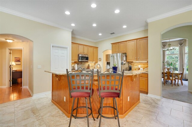 11602 Graces Way, Clermont, FL 34711 - kitchen featuring appliances with stainless steel finishes, arched walkways, recessed lighting, a breakfast bar, and ornamental molding