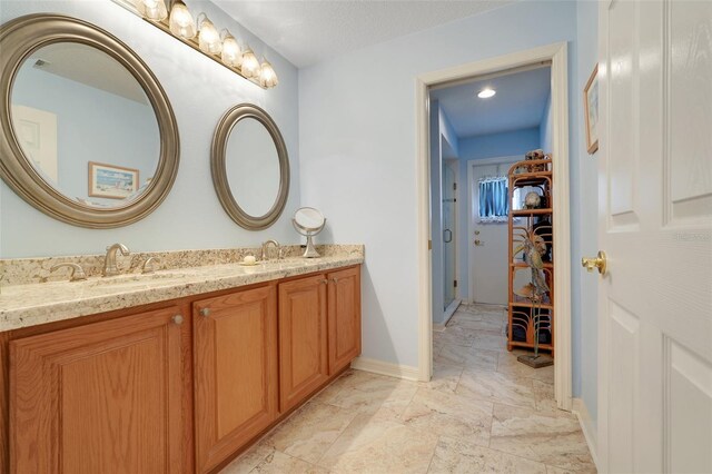 11602 Graces Way, Clermont, FL 34711 - full bathroom with double vanity, a walk in closet, and baseboards