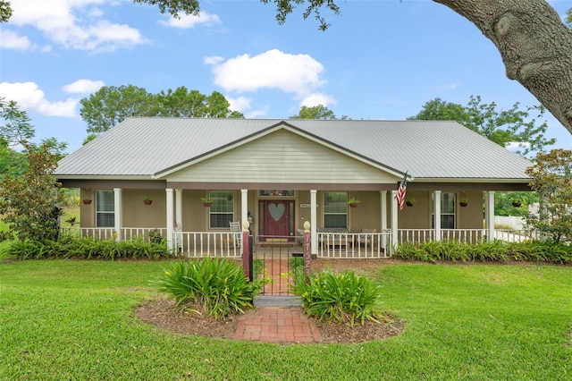 17523 Doris St, Montverde, FL 34756 - farmhouse inspired home featuring a porch, stucco siding, a front lawn, and metal roof
