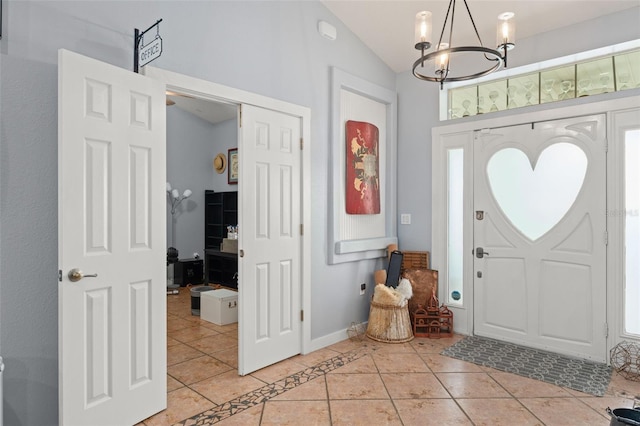 17523 Doris St, Montverde, FL 34756 - foyer entrance featuring light tile patterned floors, a chandelier, vaulted ceiling, and baseboards