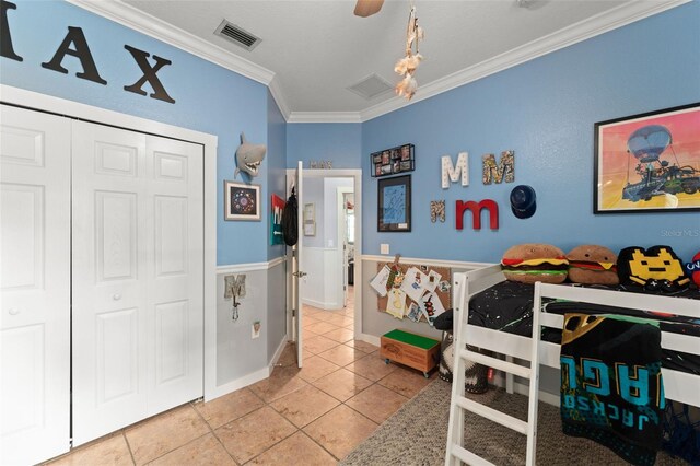 17523 Doris St, Montverde, FL 34756 - bedroom featuring ornamental molding, tile patterned floors, a closet, wainscoting, and a ceiling fan