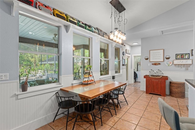 17523 Doris St, Montverde, FL 34756 - dining space featuring a wainscoted wall, light tile patterned flooring, and vaulted ceiling