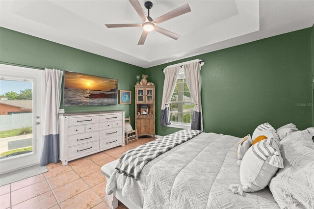 17523 Doris St, Montverde, FL 34756 - bedroom featuring access to exterior, light tile patterned floors, a tray ceiling, and ceiling fan