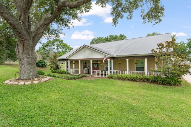 17523 Doris St, Montverde, FL 34756 - view of front facade featuring covered porch, a front lawn, stucco siding, and metal roof
