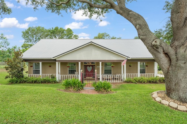 17523 Doris St, Montverde, FL 34756 - view of front of house featuring stucco siding, covered porch, a front yard, and metal roof