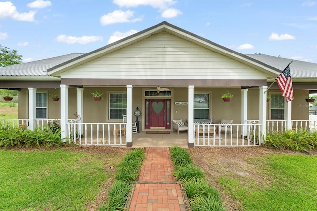 17523 Doris St, Montverde, FL 34756 - view of front facade with covered porch, stucco siding, and metal roof