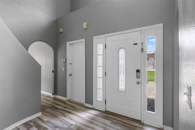 470 Regal Downs Cir, Winter Garden, FL 34787 - entrance foyer featuring wood finished floors, a towering ceiling, baseboards, and arched walkways