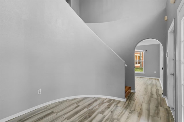 470 Regal Downs Cir, Winter Garden, FL 34787 - staircase featuring wood finished floors, arched walkways, baseboards, and a high ceiling