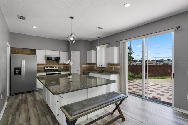 470 Regal Downs Cir, Winter Garden, FL 34787 - kitchen featuring appliances with stainless steel finishes, decorative backsplash, white cabinetry, wood finished floors, and recessed lighting