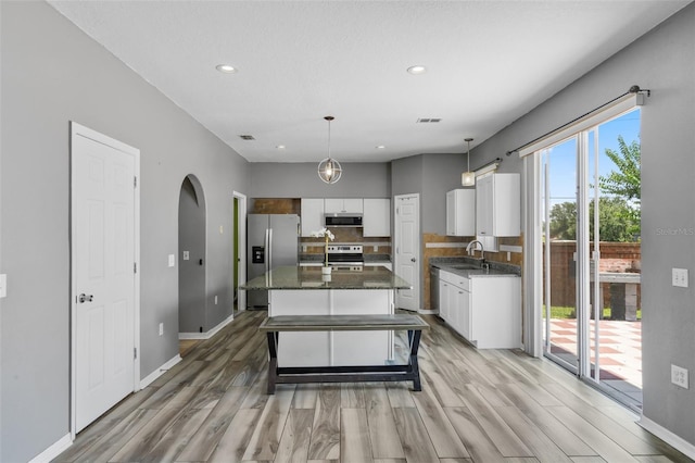 470 Regal Downs Cir, Winter Garden, FL 34787 - kitchen featuring appliances with stainless steel finishes, light wood finished floors, white cabinetry, a center island, and recessed lighting