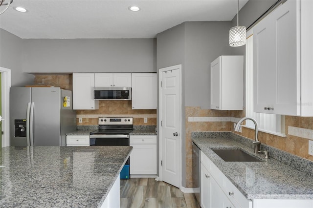 470 Regal Downs Cir, Winter Garden, FL 34787 - kitchen featuring stainless steel appliances, a sink, white cabinetry, dark stone counters, and recessed lighting