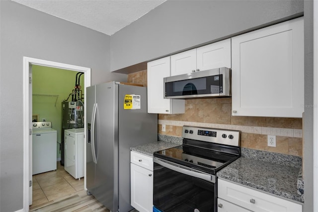 470 Regal Downs Cir, Winter Garden, FL 34787 - kitchen featuring stainless steel appliances, washing machine and clothes dryer, decorative backsplash, white cabinets, and stone counters