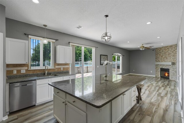 470 Regal Downs Cir, Winter Garden, FL 34787 - kitchen featuring dishwasher, light wood finished floors, plenty of natural light, a sink, and a textured ceiling