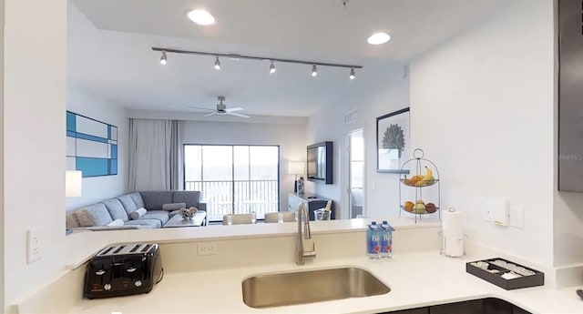 14501 Grove Resort Ave Unit 2440, Winter Garden, FL 34787 - kitchen featuring a sink, light countertops, ceiling fan, open floor plan, and rail lighting