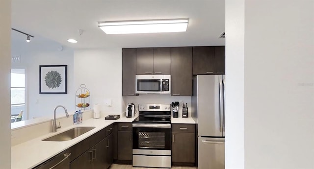 14501 Grove Resort Ave Unit 2440, Winter Garden, FL 34787 - kitchen featuring stainless steel appliances, a sink, light countertops, dark brown cabinets, and a peninsula