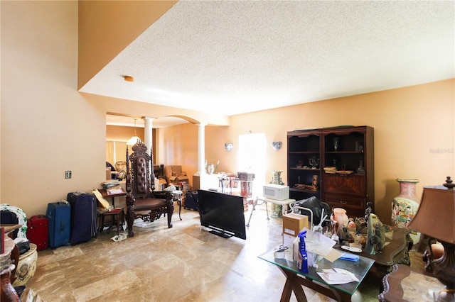 2305 Rio Grande Forest Ln, Kissimmee, FL 34759 - living area featuring decorative columns, a textured ceiling, and arched walkways